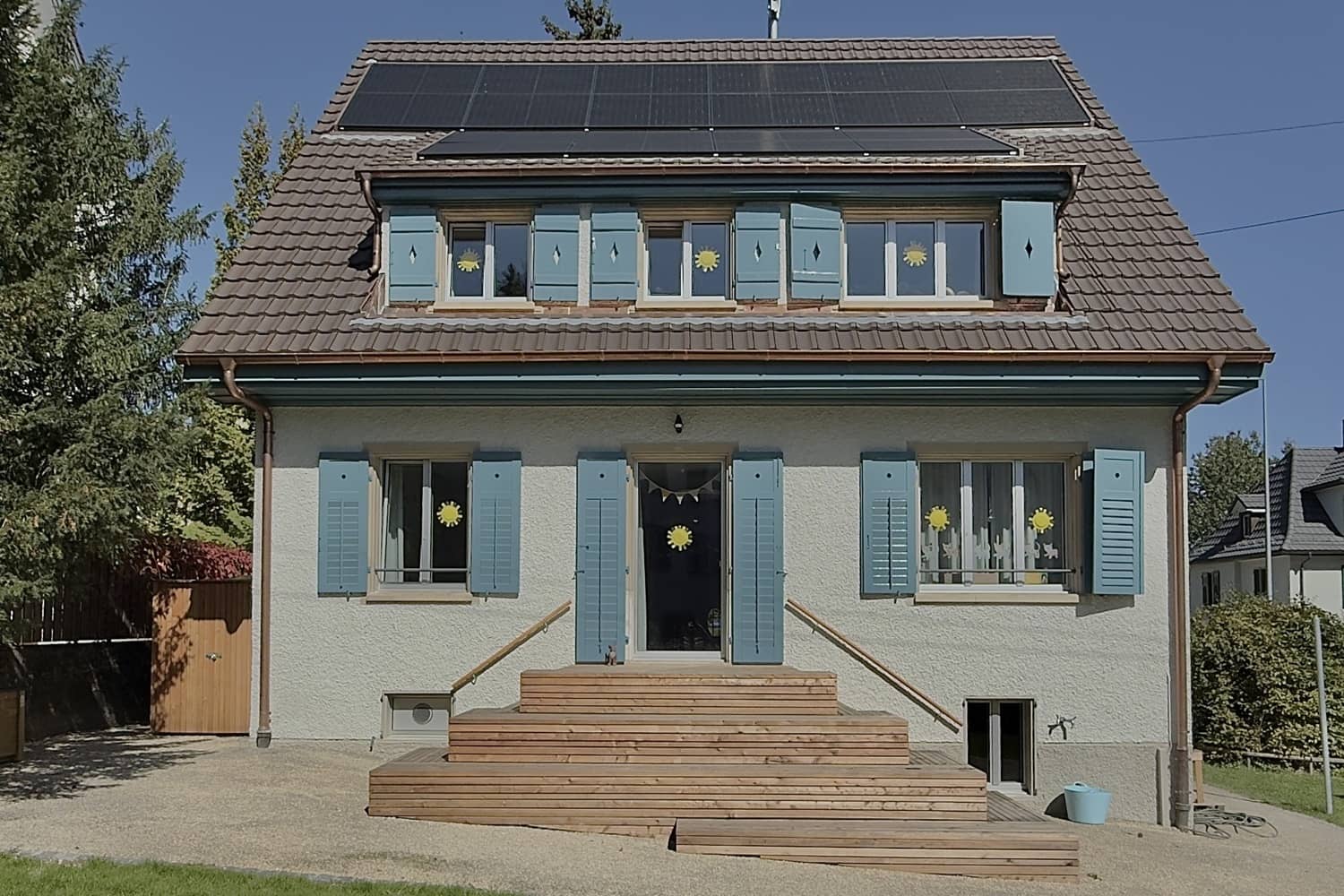 Aussenansicht eines h&uuml;bschen Hauses mit Gibeldach und blauen Fensterl&auml;den